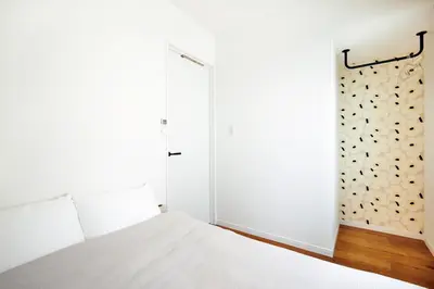 a bedroom with a white bed and a sliding door at HeySky Oshiage in Tokyo