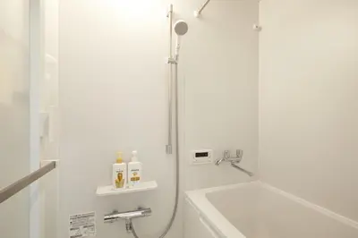 a white bathroom with a shower and a sink at HeySky Oshiage in Tokyo