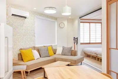 a living room with a couch and a bed at HeySky Oshiage in Tokyo