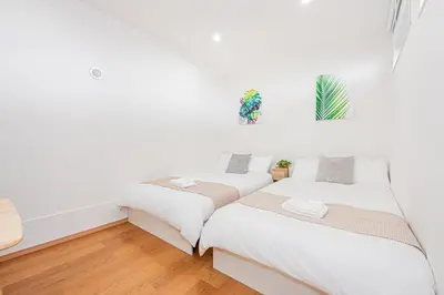 two beds in a room with white walls and wooden floors at Mori House \u795e\u697d\u5742 in Tokyo