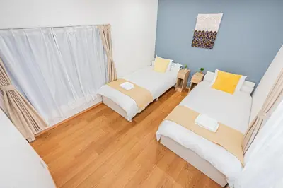 two beds in a room with blue walls and wooden floors at Mori House \u795e\u697d\u5742 in Tokyo