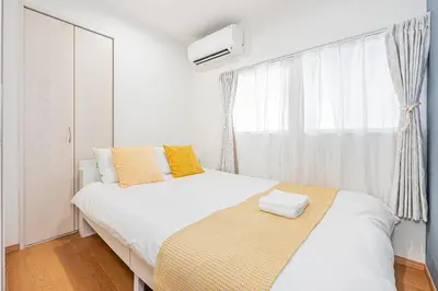 a white bedroom with a bed and a window at Mori House \u795e\u697d\u5742 in Tokyo
