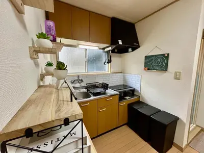 a small kitchen with brown cabinets and a sink at Tokyo Love House 2 in Tokyo