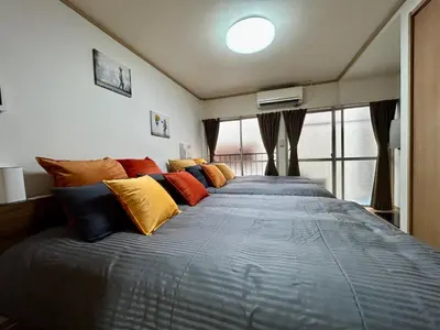 a bedroom with a large bed with colorful pillows at Tokyo Love House 2 in Tokyo