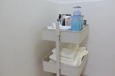 a bathroom with a sink with towels and a shelf at \u845b\u98fe\u533a\u306e\u4e00\u8ed2\u5bb6\u307e\u308b\u307e\u308b\u8cb8\u3057\u5207\u308a in Tokyo