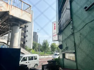 a green building with a sign on the side of it at \u845b\u98fe\u533a\u306e\u4e00\u8ed2\u5bb6\u307e\u308b\u307e\u308b\u8cb8\u3057\u5207\u308a in Tokyo