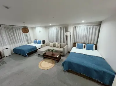 a hotel room with two beds and a couch at Yamanote Line to Shinjuku or Shibuya in Tokyo