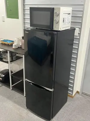 a black refrigerator with a microwave on top of it at Yamanote Line to Shinjuku or Shibuya in Tokyo