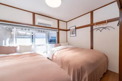 two beds in a room with a window at Homie Hiroo in Tokyo