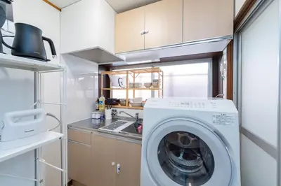 a kitchen with a washing machine in a kitchen at Homie Hiroo in Tokyo