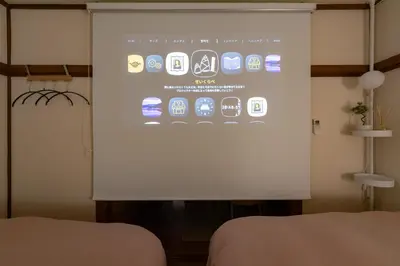 a projection screen in a room with two beds at Homie Hiroo in Tokyo