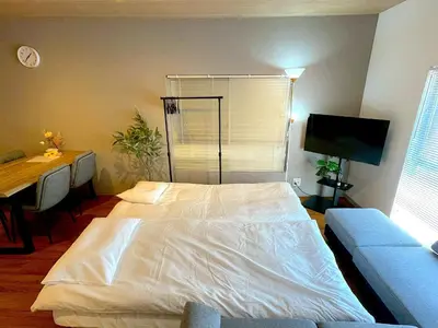 a bedroom with a white bed and a couch at Shibamata house self check in in Tokyo