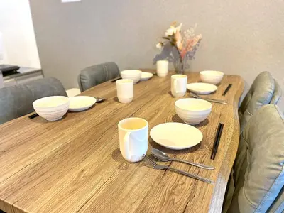 a wooden table with white bowls and plates on it at Shibamata house self check in in Tokyo