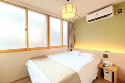 a bedroom with a bed and two windows at Racto Hotel Higashijujo \u697d\u9014\u30db\u30c6\u30eb \u6771\u5341\u6761 in Tokyo