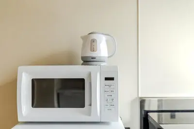 a white microwave sitting on top of a counter at Racto Hotel Higashijujo \u697d\u9014\u30db\u30c6\u30eb \u6771\u5341\u6761 in Tokyo