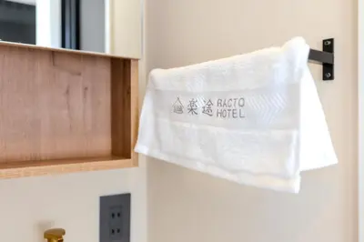 a towel hanging on the door of a bathroom at Racto Hotel Higashijujo \u697d\u9014\u30db\u30c6\u30eb \u6771\u5341\u6761 in Tokyo