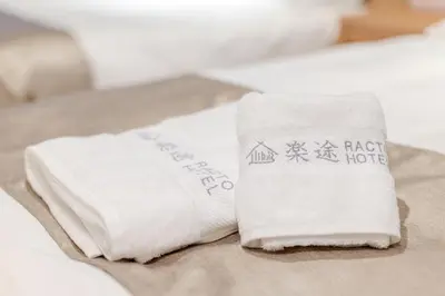 two white towels sitting on top of a bed at Racto Hotel Higashijujo \u697d\u9014\u30db\u30c6\u30eb \u6771\u5341\u6761 in Tokyo