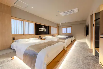 a bedroom with three beds and a flat screen tv at Racto Hotel Higashijujo \u697d\u9014\u30db\u30c6\u30eb \u6771\u5341\u6761 in Tokyo