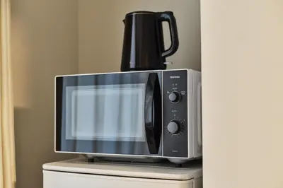 a microwave oven sitting on top of a cabinet at \u65b0\u5bbf\u5340\u6771\u65b0\u5bbf\u7ad9\u8fd1\u9130\u6b4c\u821e\u4f0e\u807d\u4f0a\u52bf\u4e39\u623f\u6e90\u514d\u8cbbWi-Fi#10 in Tokyo