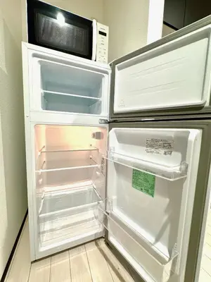a refrigerator with its door open and a microwave above it at Enjoy Koenji 202, 1 bedroom, 7 min from Sta in Tokyo