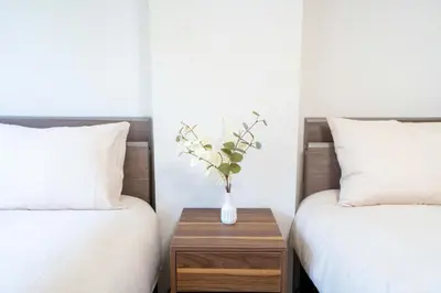 a vase of flowers on a table between two beds at Free parking Shiinamachi Station 10 min walk Convenient transportation One stop direct to Ikebukuro in Tokyo