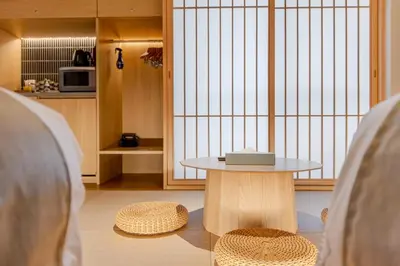 a table and two stools in a room with a kitchen at Racto Hotel Ikebukuro \u697d\u9014\u30db\u30c6\u30eb \u6c60\u888b in Tokyo