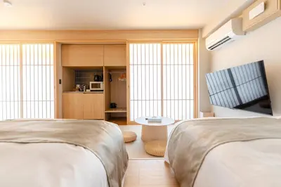 a bedroom with two beds and a table and a tv at Racto Hotel Ikebukuro \u697d\u9014\u30db\u30c6\u30eb \u6c60\u888b in Tokyo