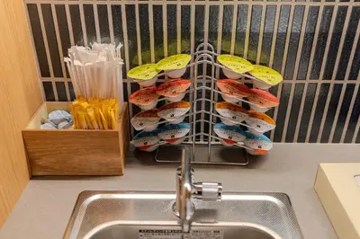 a kitchen counter with a sink and a rack of sushi at Racto Hotel Ikebukuro \u697d\u9014\u30db\u30c6\u30eb \u6c60\u888b in Tokyo