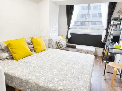 a bedroom with a bed with yellow pillows and a window at Shinjuku Tokyo \u6771\u4eac\u65b0\u5bbf SS in Wada