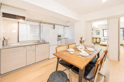 a kitchen and dining room with a wooden table and chairs at Tawaramachi Stay 2 minutes' walk from Tawaramachi Station and 10 minutes' walk from Asakusa Station in Tokyo