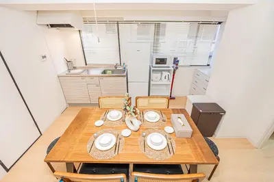 a kitchen with a wooden table and chairs in a room at Tawaramachi Stay 2 minutes' walk from Tawaramachi Station and 10 minutes' walk from Asakusa Station in Tokyo