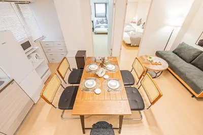 a dining table and chairs in a living room at Tawaramachi Stay 2 minutes' walk from Tawaramachi Station and 10 minutes' walk from Asakusa Station in Tokyo
