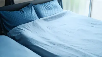 a white bed with blue sheets and a window at 15minutes walk from Skytree -Mukojima House- in Tokyo