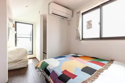 a bedroom with a colorful blanket on a bed at Met\u539f\u753a1\u4e01\u76ee in Tokyo