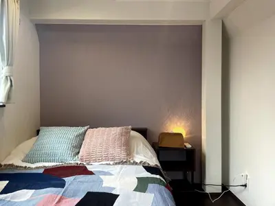 a bedroom with a bed with colorful pillows on it at Met\u539f\u753a1\u4e01\u76ee in Tokyo