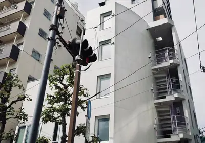 a traffic light in front of a tall building at Tokyo Oji Apartment 3B in Tokyo