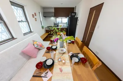 a living room with a wooden table with flowers on it at Kameari House Serene Japanese-Inspired Stay in Residential Tokyo in Tokyo