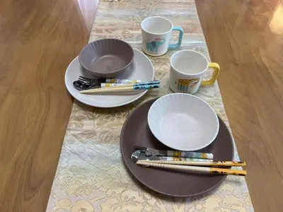 a table with two plates and two cups and chopsticks at Kameari House Serene Japanese-Inspired Stay in Residential Tokyo in Tokyo
