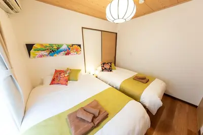 two beds in a small room with a mirror at Kameari House Serene Japanese-Inspired Stay in Residential Tokyo in Tokyo