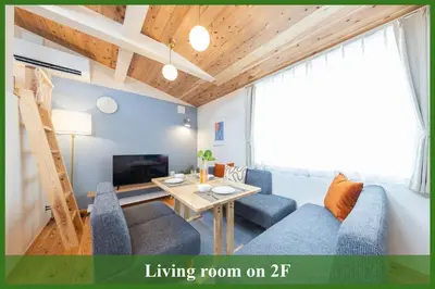 a living room with a blue couch and a table at Direct to Asakusa Ginza & NRT HND 2025 New House in Tokyo