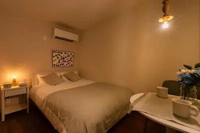 a bedroom with a bed and a table with flowers on it at THE CAMINO Nakano 302 in Tokyo