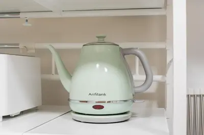 a white electric tea kettle sitting in a refrigerator at THE CAMINO Nakano 302 in Tokyo