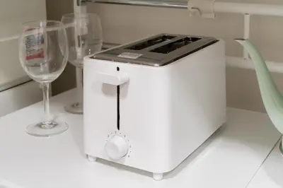 a white kitchen with two wine glasses on a counter at THE CAMINO Nakano 302 in Tokyo