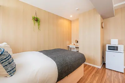 a bedroom with a white bed and a microwave at Komorebi Asakusa Cozy 4P Stay The 77 House Tokyo in Tokyo