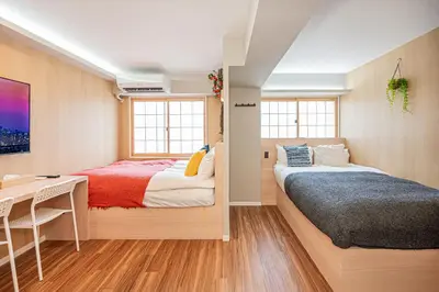 a bedroom with two beds and a table and a desk at Komorebi Asakusa Cozy 4P Stay The 77 House Tokyo in Tokyo