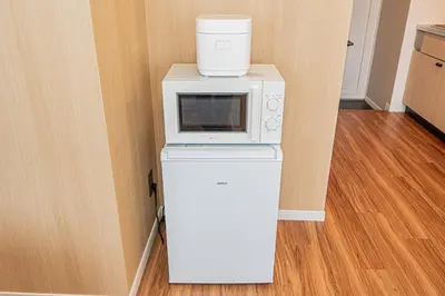 a white microwave sitting on top of a refrigerator at Komorebi Asakusa Cozy 4P Stay The 77 House Tokyo in Tokyo