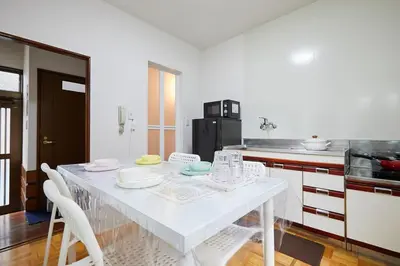 a kitchen with a white table with chairs in it at Sweet House\u6771\u6c60\u888b in Tokyo