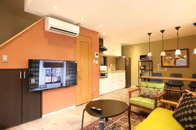 a living room with a couch and a tv on a wall at Shinjuku Gyoen house 2LDK in Tokyo