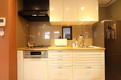 a kitchen with white cabinets and a sink at Shinjuku Gyoen house 2LDK in Tokyo