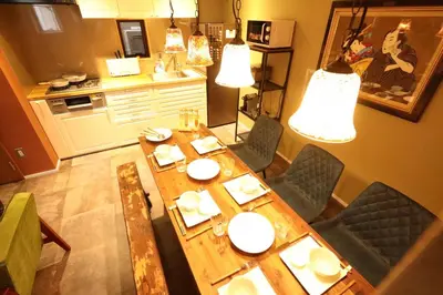 a kitchen with a wooden table and chairs and lights at Shinjuku Gyoen house 2LDK in Tokyo